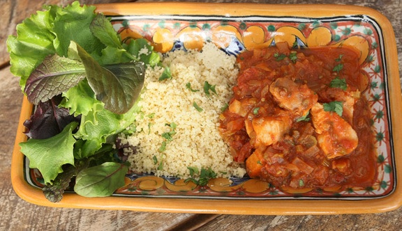 Morocco fish stew, plated with salad and couscous