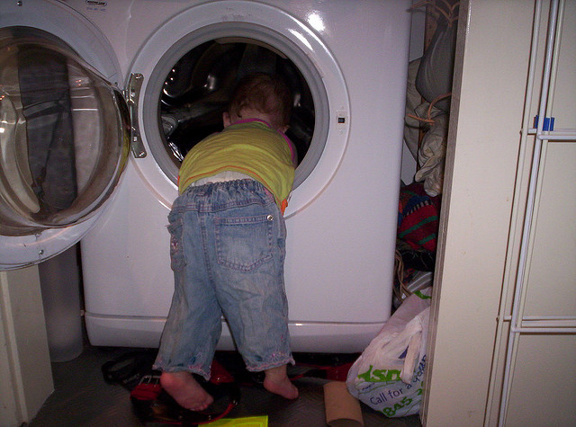 toddler peeking into the washing machine