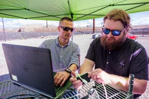Sandia National Laboratories cybersecurity expert Adrian Chavez, left, and computer scientist Logan Blakely work to integrate a single-board computer with their neural-network AI into the Public Service Company of New Mexico’s test site. This code monitors the grid for cyberattacks and physical issues.