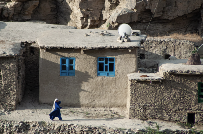 Afghanistan woman walking in village, blue windows