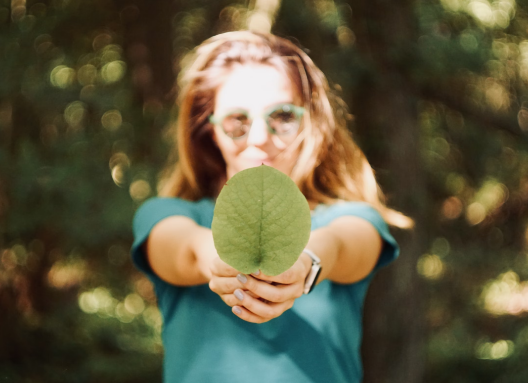 ESG coach, holding green leaf