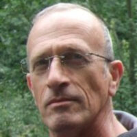 A vast field of solar mirrors, at the Ivanpah solar energy facility, reflecting sunlight toward tall central towers, against a desert landscape. Moshe Luz