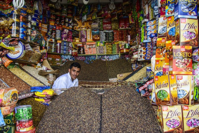 Man sitting in his full shop in the Old Town, UNESCO World Heritage Site, Sanaa, Yemen, Middle East