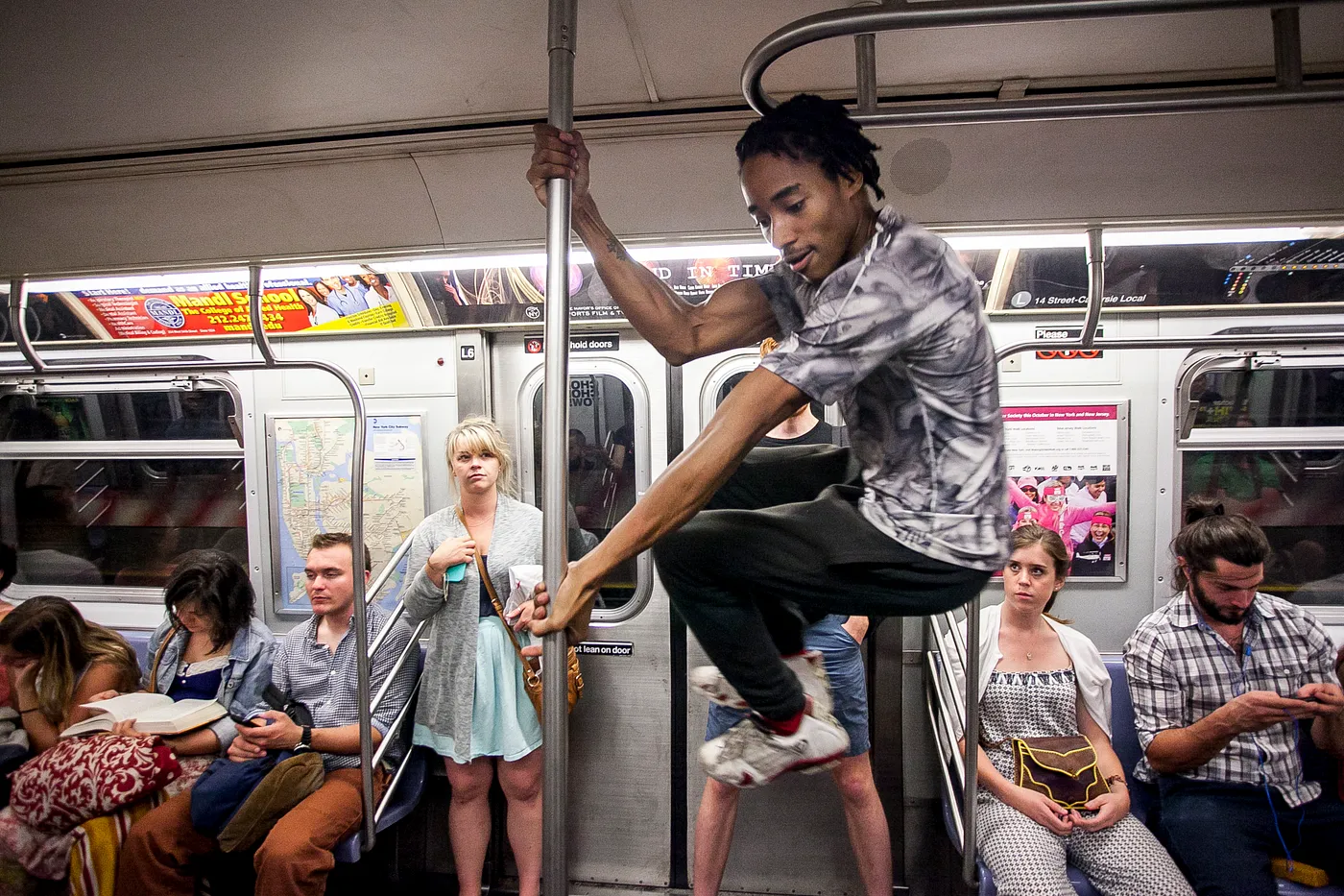 An acrobat on the E Line, NYC.  (Samira Bouaou/Epoch Times)