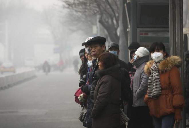 Commuters, some wearing masks to protect themselves from pollutants, wait at a bus stand on a heavily polluted day in Beijing, Monday, Nov. 30, 2015. Beijing on Sunday, Nov. 29 issued its highest smog alert of the year following air pollution in capital city reached hazardous levels as smog engulfed large parts of the country despite efforts to clean up the foul air. (AP Photo/Andy Wong)