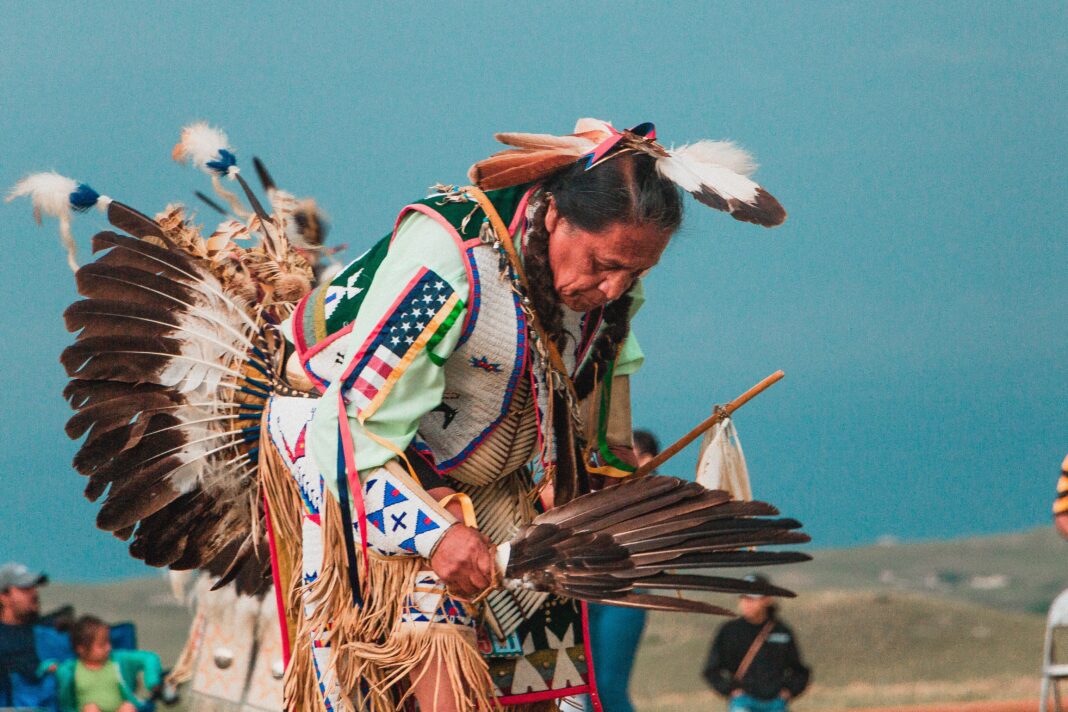 first nations man dancing in traditional costume