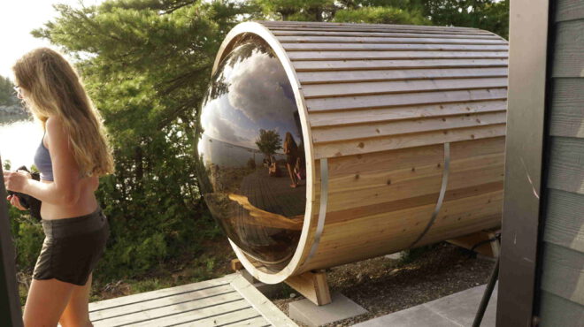Barrel sauna, panoramic window, serene beauty, lush forest, precision-crafted, cylindrical design, nature integration, wellness experience, unobstructed view, tranquil ambiance, rustic charm, modern functionality, charming retreat, contemporary luxury, natural splendor, rejuvenating journey, heart of the forest, sauna escape, forest sanctuary, soothing warmth, panoramic serenity.