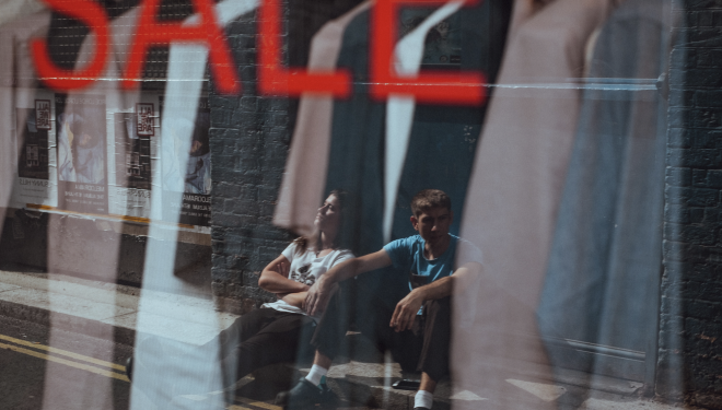 Black Friday, buy nothing, young couple sitting in window looking
