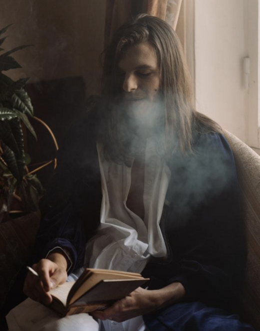 hipster reads book while smoking a joint