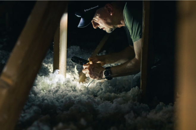 man installing insulation in dark attack
