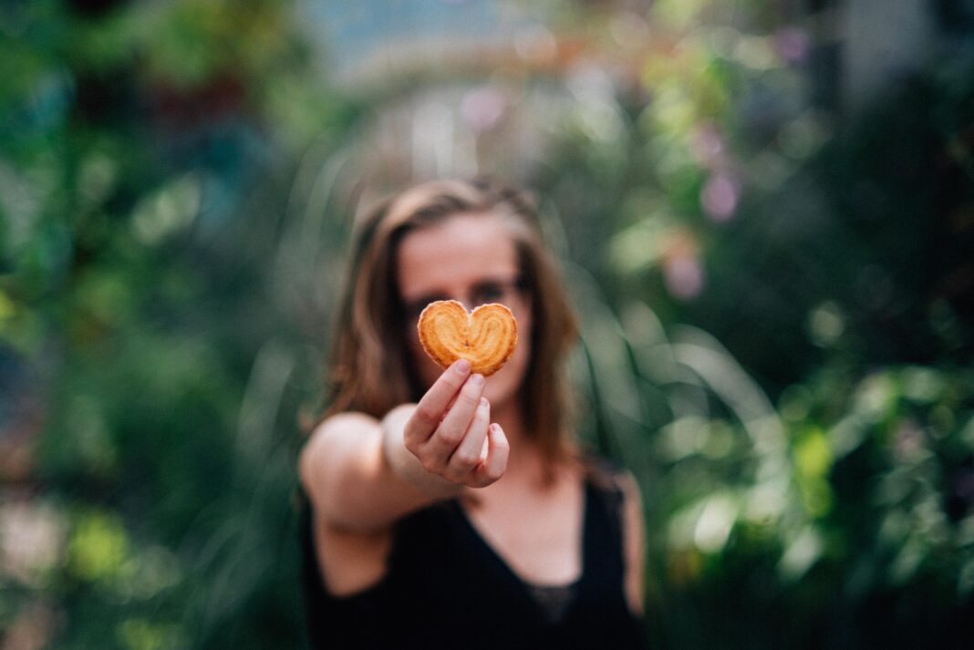 eco coach, woman holding cookie heart in forest