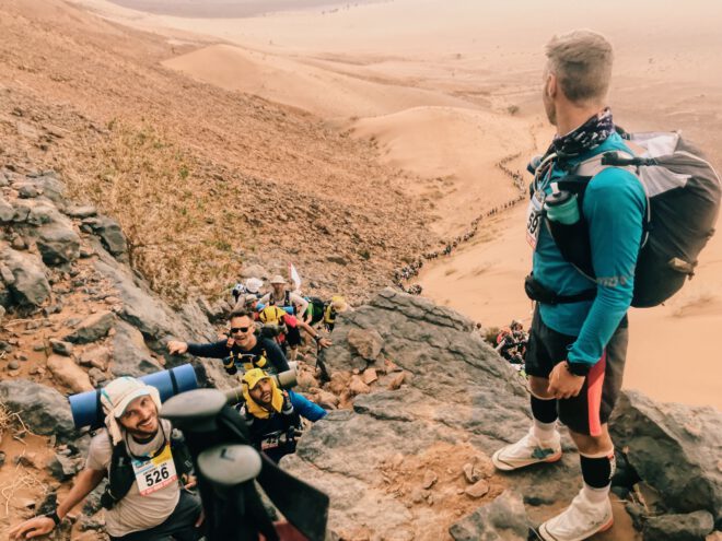 Participants helping each other up the mountains, Marathons des Sables, marathon in the Middle East