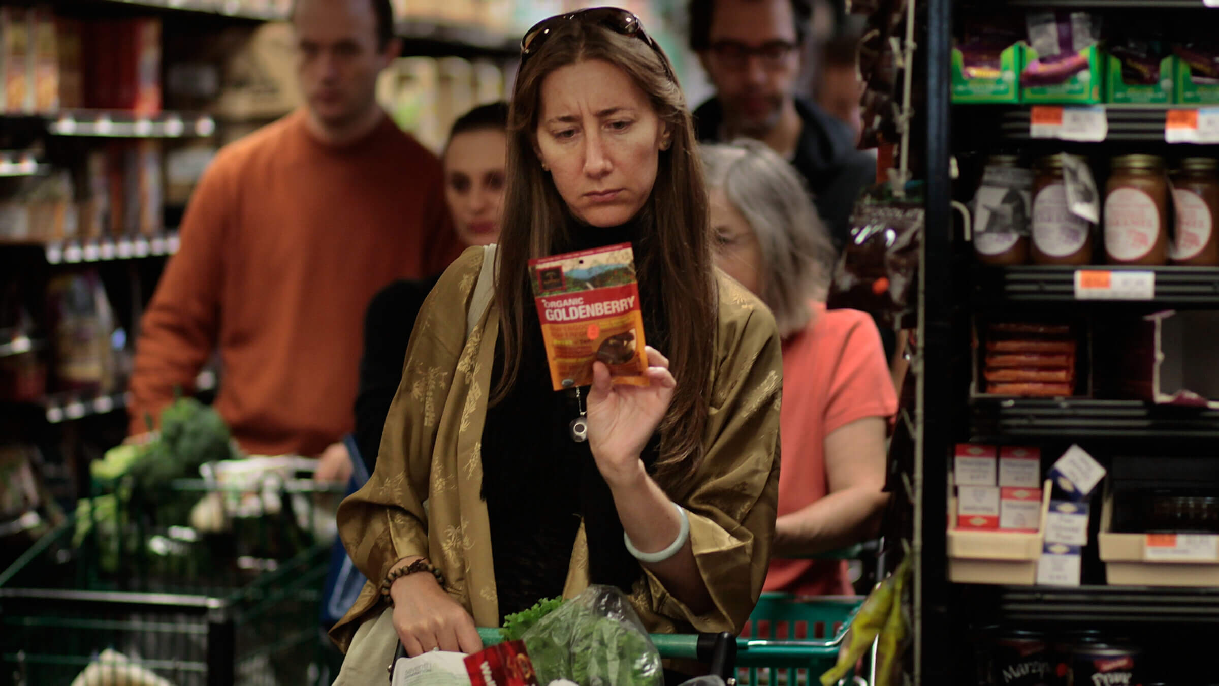 A woman carefully reading the label on a product at the Park Slope Food Coop. Photo by Getty Images