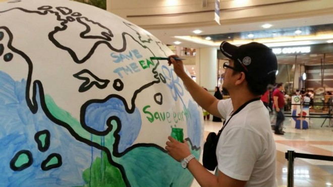 Man painting a giant globe