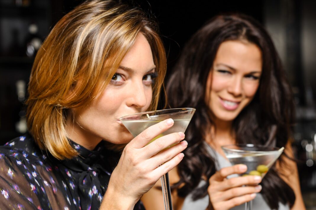 attractive women drinking martinis, smiling
