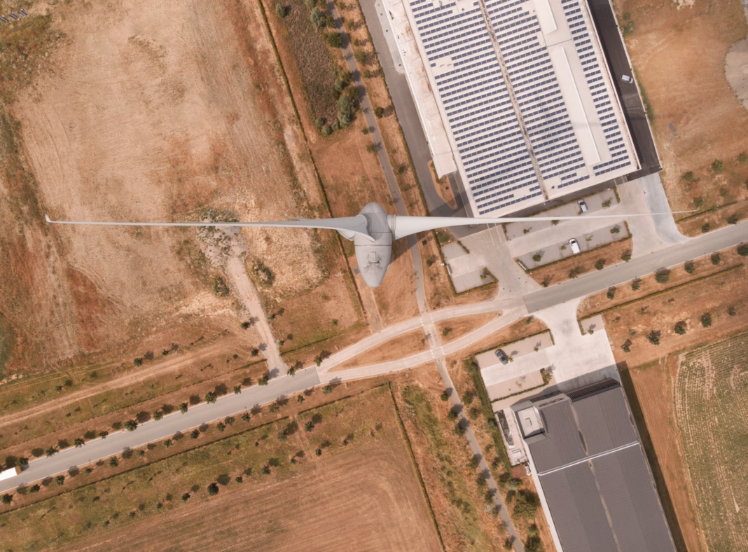 wind turbine, drone above looking down over the blades onto land